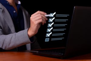 Profissional preenchendo um checklist de recebimento de mercadorias em formato digital durante o processo de conferência logística.