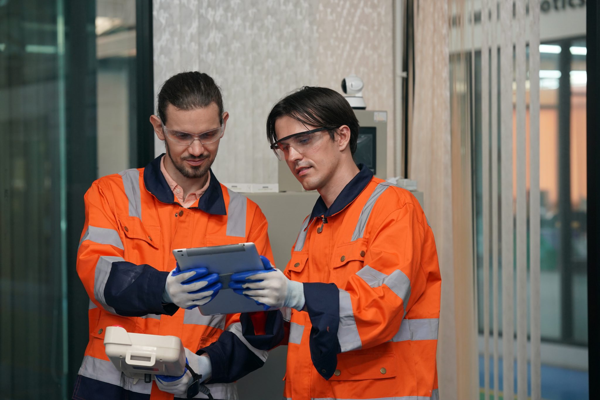 Técnicos usando tablet para controle de manutenção corretiva em ambiente operacional.
